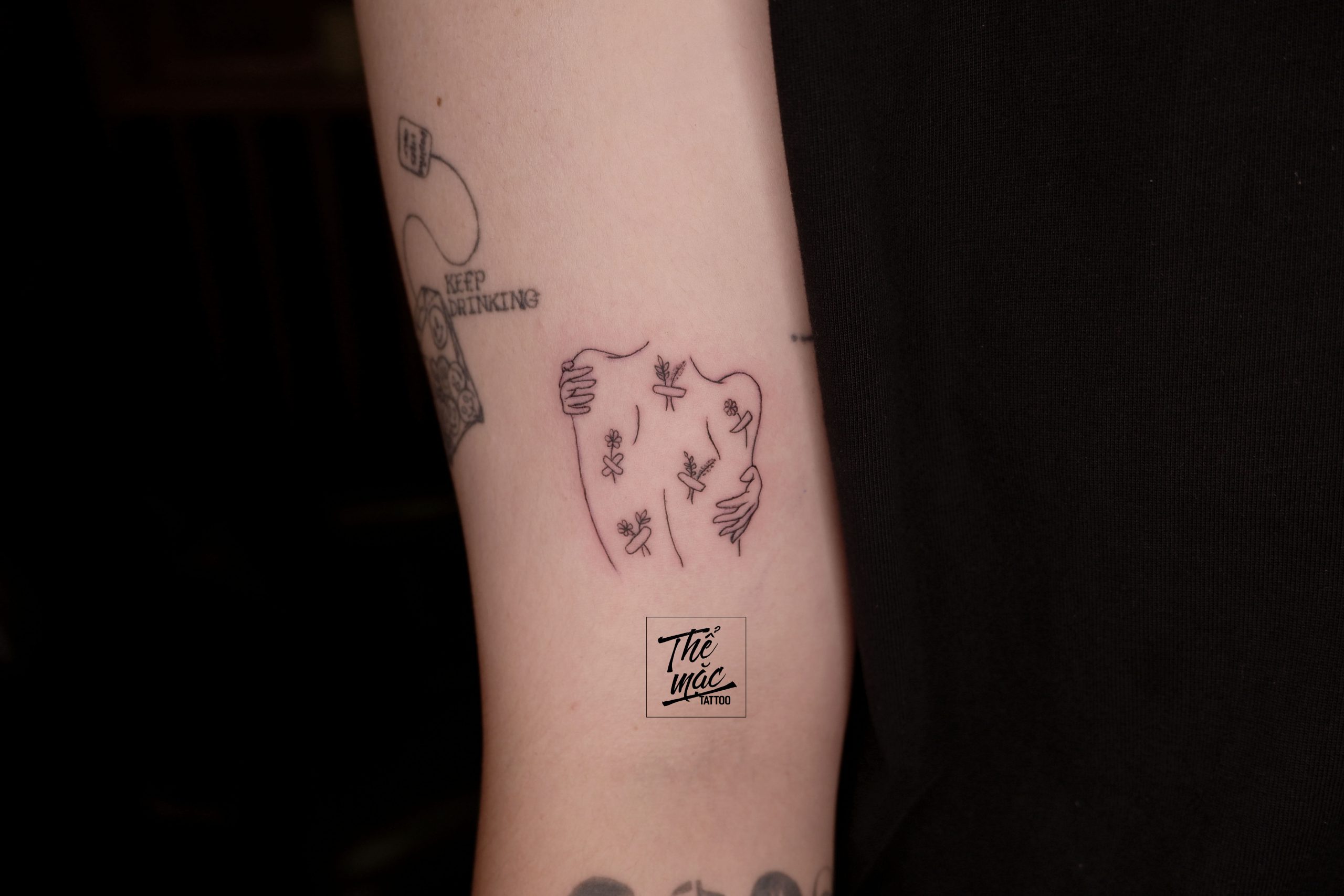 Abstract fine line tattoo of a body embraced by flowers – delicate and emotional ink work from Thể Mặc Tattoo.